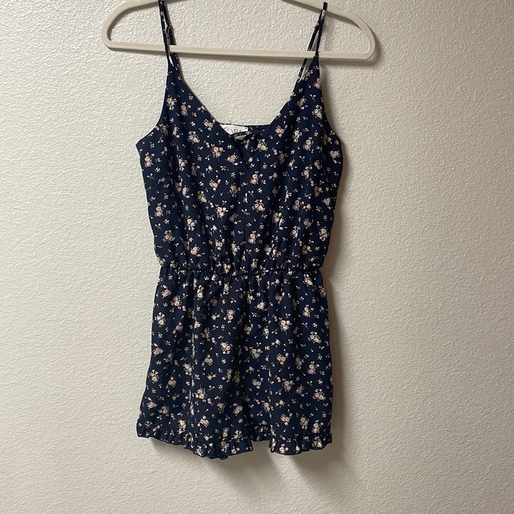 Cute navy blue romper with pink and yellow flower pattern.